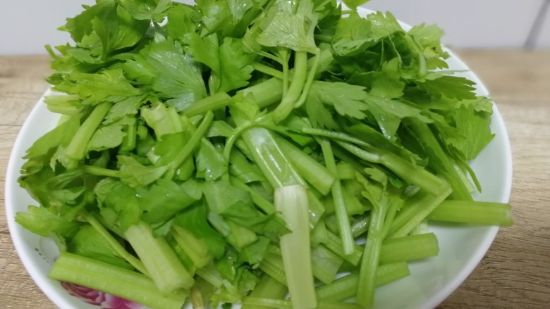 芹菜炒肉,芹菜叶子比芹菜降压效果好。留下嫩叶，一同和芹菜切成段，盛盘。