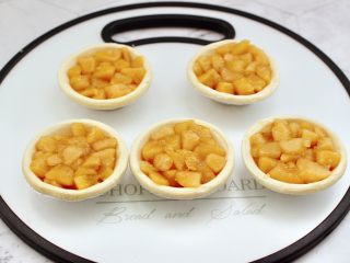 苹果蛋挞酥,把凉透的苹果馅盛入蛋挞皮里，注意一定要装的饱满一些，这样烤出来的外形好看。