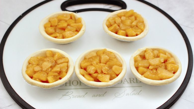 苹果蛋挞酥,把凉透的苹果馅盛入蛋挞皮里，注意一定要装的饱满一些，这样烤出来的外形好看。