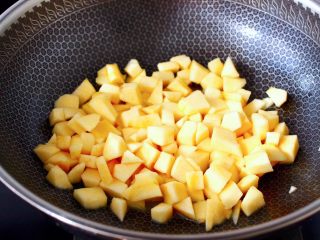 苹果蛋挞酥,加入切丁的苹果翻炒均匀。