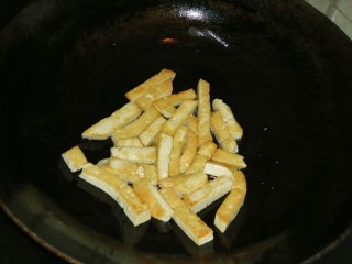 韭菜炒豆腐,把豆腐慢火煎成金黄色。