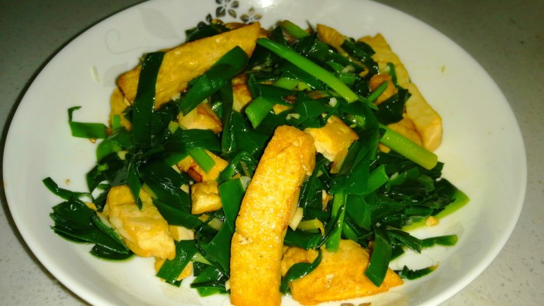 韭菜炒豆腐,入味均匀，盛入盘中。