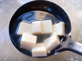 菠菜豆腐汤,锅中倒入适量清水和高汤烧开放入豆腐大火煮开