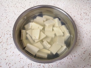 韭菜炒豆腐,放入淡盐水里面浸泡15分钟左右（用淡盐水浸泡可以去除豆腐的豆腥味，也可以让豆腐入一点底味）。