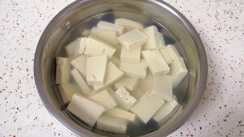 韭菜炒豆腐,放入淡盐水里面浸泡15分钟左右（用淡盐水浸泡可以去除豆腐的豆腥味，也可以让豆腐入一点底味）。