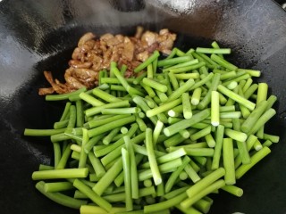 蒜苔炒牛肉,牛肉推到锅的一侧，倒入蒜薹段，急火翻炒均匀。