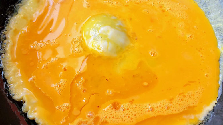 茼蒿炒鸡蛋,锅中倒入适量油加热再倒入打散的蛋液