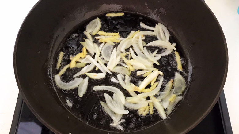 茼蒿炒鸡蛋,炒锅烧热后加入1小勺玉米油，油烧热后加入葱姜，炒出香味