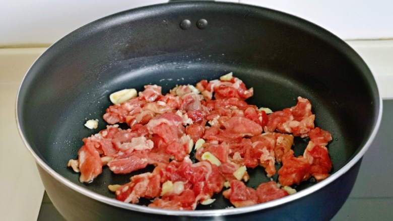 芦笋炒肉片,起油锅，加入切好的蒜末煸炒出香味，再加入腌制好的牛肉。