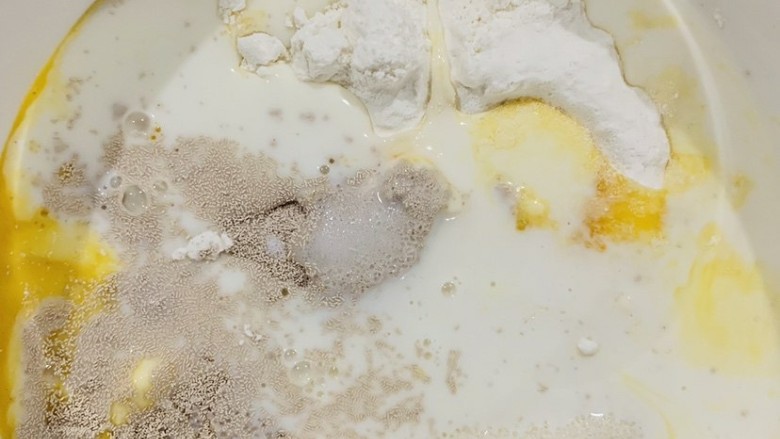 菠萝面包,先做面包部分是，将准备好的高筋粉，鸡蛋，白砂糖，盐，酵母，牛奶依次按顺序倒入容器中