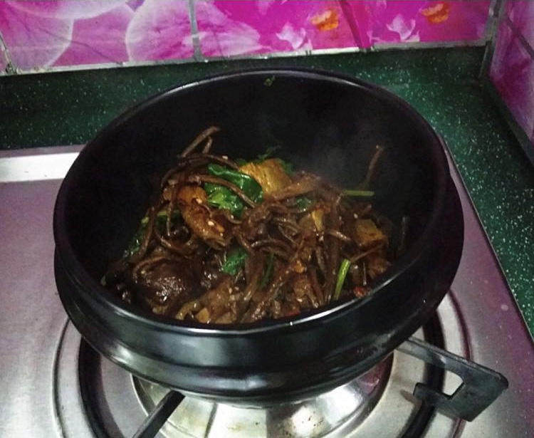 麻辣香锅茶树菇,再撒点芝麻和香菜，最后将它们盛入已烧热的石锅中