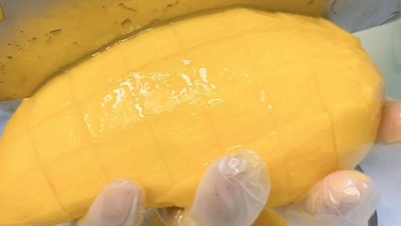 芒果西米捞,然后竖切，尽量做到大小均匀，这样切出来的芒果肉块更好看。
