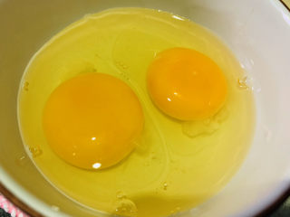 茼蒿炒鸡蛋,鸡蛋打入碗内；