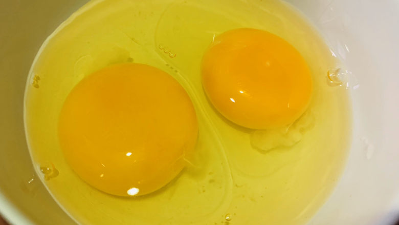 茼蒿炒鸡蛋,鸡蛋打入碗内；