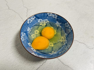 菠萝虾仁炒饭,鸡蛋打入碗中