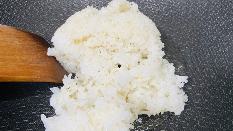 菠萝虾仁炒饭,锅中加入适量食用油加热至七成热倒入白米饭翻炒片刻