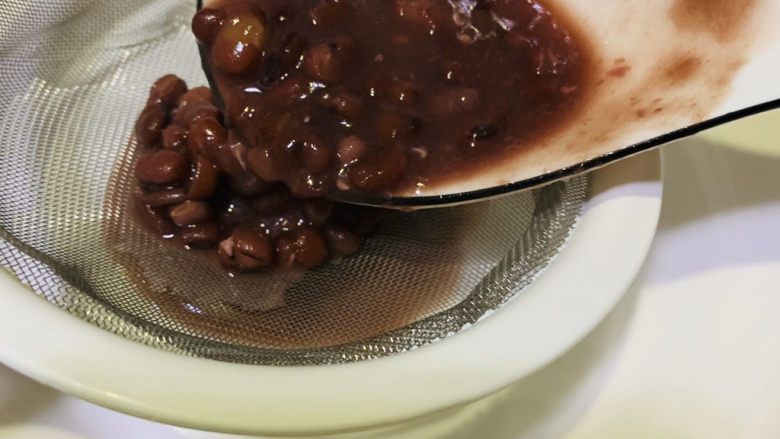 自制“红豆沙”馅,用漏勺把红豆汤过滤倒一个碗内，红豆汤可以喝，不要按压哦；