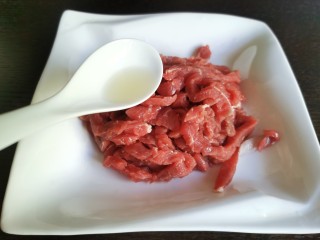 蒜苔炒牛肉,牛里脊肉泡去血水洗净，切成牛肉丝。加入料酒去腥。