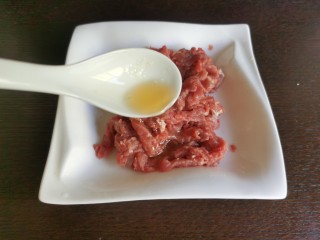 蒜苔炒牛肉,最后再往肉丝里加入两勺的食用油，抓匀后腌制入味。