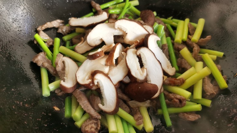 蒜苔炒牛肉,放入蒜苔和香菇。