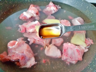 花生莲藕排骨汤,排骨冷水下锅加生姜片与一勺料酒开大火焯水。