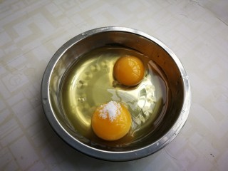 茼蒿炒鸡蛋,鸡蛋打入碗中，放少许盐