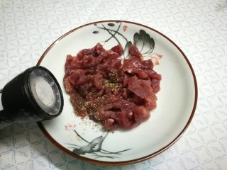 蒜苔炒牛肉,将黑胡椒粒摩擦成黑胡椒碎，放入盘中