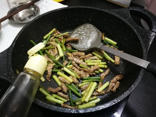 蒜苔炒牛肉,放入少许适量生抽，翻炒均匀