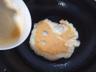 茼蒿炒鸡蛋,锅里油热倒入蛋液两面煎微黄
