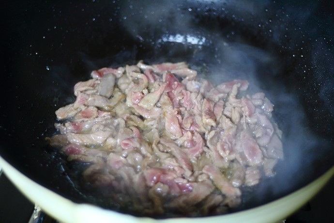 蒜苔炒牛肉,起锅烧热油，把牛肉先过油。