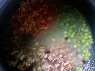 一颗番茄拌饭,锅中放入火腿粒、豌豆、胡萝卜粒和香菇粒。