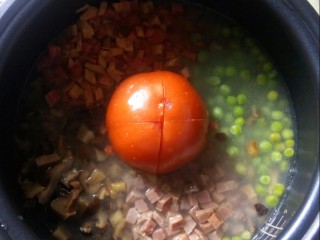 一颗番茄拌饭,番茄切十字花刀，放入锅中。