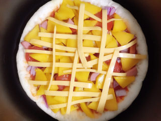 芒果披萨,等按钮弹起来时就可以揭开锅盖，将奶酪丝摆在披萨上面