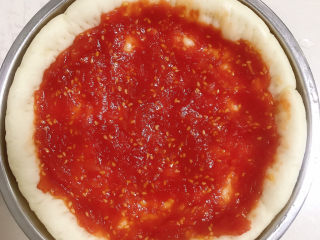 芒果披萨,将番茄酱抹在披萨饼上