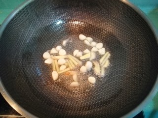 麻辣香锅,锅中放少许油，放入蒜瓣和姜片炒香