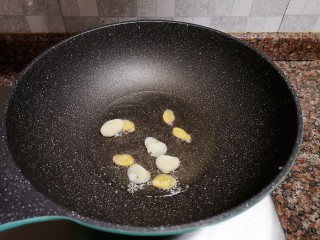 茼蒿炒鸡蛋,放入大蒜生姜片翻炒出香味。