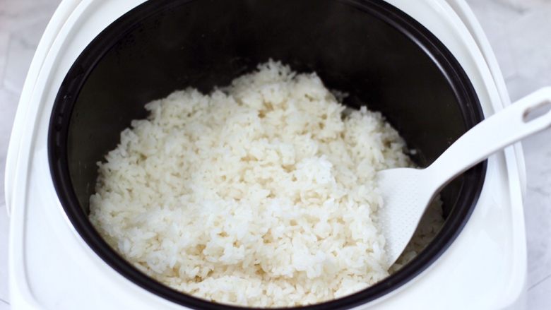 香椿红虾饭团,启动煮饭模式煮熟米饭，把煮熟的米饭用锅铲打散放凉备用。