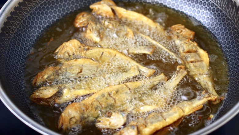 香脆椒干煸黄花鱼,再把油烧热后，放入炸好的黄花鱼复炸一次，这样炸的黄花鱼酥脆香浓，连鱼刺都炸酥了，可以一起吃。
