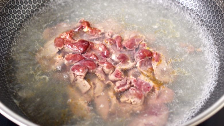 香脆椒爆蒜苔鸡肝,锅中倒入适量，加入1勺盐烧开，把腌制好的鸡肝下锅。