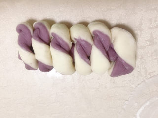 紫薯双色馒头,再将尾部对折上去并稍微按压一下，让头尾粘在一起，反个面稍微整下型