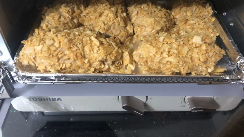 薯片鸡翅,全部做好后摆在铺有锡纸的烤盘上。放入180度预热好的烤箱里。