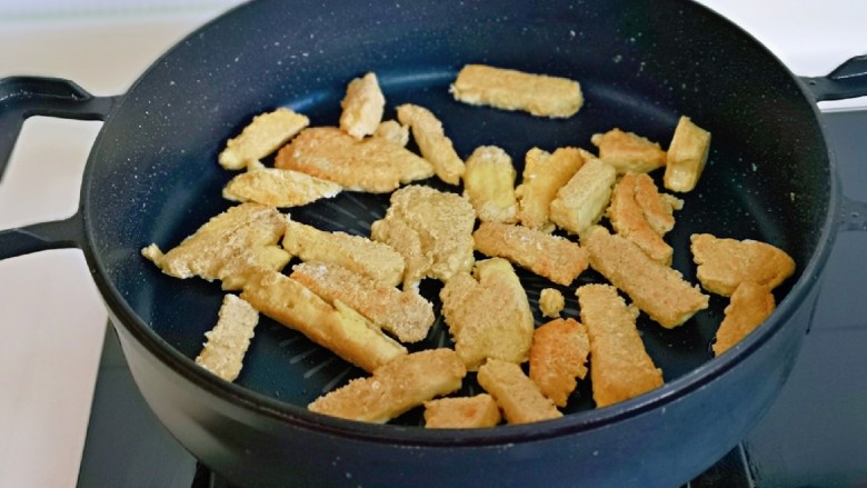 韭菜炒素鸡,起油锅，加入素鸡条煎至金黄。