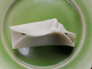 韭菜猪肉馅水饺,将饺子皮对折然后用水粘住中间，然后两边向中间捏褶子