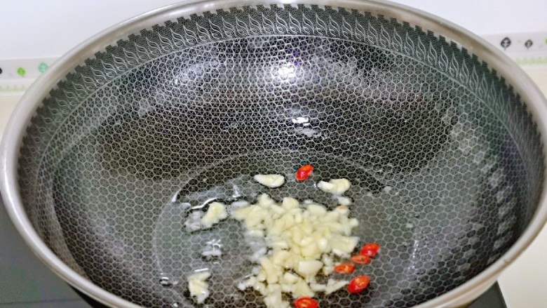 爆炒卷心菜,起油锅，加入蒜末与辣椒煸炒。