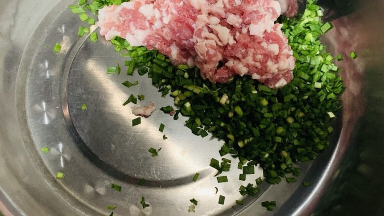 韭菜猪肉包子,韭菜和猪肉剁碎放入盆里。