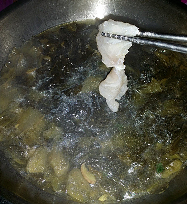 酸汤龙利鱼,将腌好的鱼片一片片，滑入锅中
