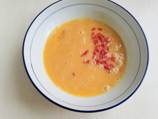 牡蛎炒蛋,打散的蛋液中加入红椒丁拌匀。