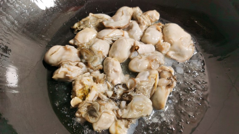 牡蛎炒蛋,  炒锅烧热放油，倒入牡蛎肉稍稍煎它一下。牡蛎煎的时间不要长了，防止变老。