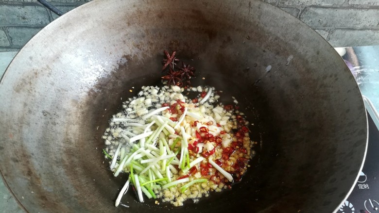 紫苏炒田螺,加入蒜末，姜末，葱白和干辣椒，继续煸出香味