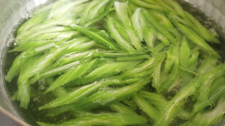 芹菜拌腐竹,锅里放水烧开，放入一小勺食盐，放入芹菜焯水。加盐焯水后的芹菜颜色会更加的翠绿。
